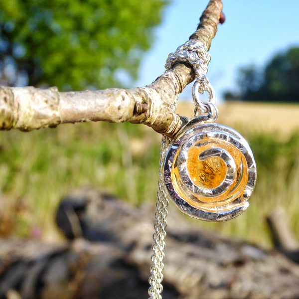 Golden citrine set within a textured silver spiral.